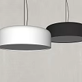 Two Modern White and Black Round Pendant Lights Illuminated Against Gray Wall