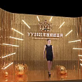 YY2021 Annual Ceremony Scene With Golden Tassel Backdrop Woman In Black Dress And Decorative Balls