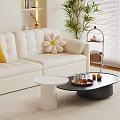 Modern White Sofa with Pillows and White Black Round Coffee Tables in Living Room Interior