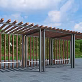 Wooden Pergola With Metal Support Columns Benches In Green Landscape Under Blue Sky