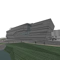 Modern Museum Building With Geometric Structure Glass Facade And Waterfront Grassy Area Under Cloudy Sky