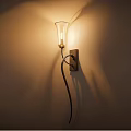 Elegant Wall Lamp with Glass Shade and Metal Bracket Emitting Warm Light on Wall