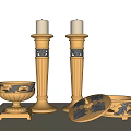 Two Elegant Golden Candle Holders With Small Golden Bowl And Dishes On Light Colored Wall Background