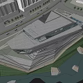 Modern Museum Building With Geometric Structure Glass Facade And Waterfront Grassy Area Under Cloudy Sky