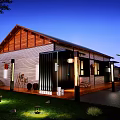 Rustic Guesthouse Building With Wooden Roof Stone Walls Front Porch Clay Pots Purple Flowers