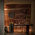 Other Bathroom Featuring Brown Textured Wall Round Mirror Warm Lighting Green Plant And Wooden Countertop
