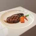 Grilled Steak Plated with Green Vegetables Carrots and Red Sauce on White Square Plate