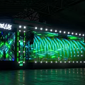 Vibrant Stage With PULSE LED Screens Green Lights And Audience Glow Sticks