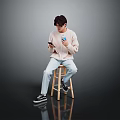 Man Sitting On Wooden Stool Holding Phone And Blue Cup In Light Sweater