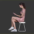 Woman Sitting On Chair In Floral Dress Using Smartphone With White Sneakers And Gray Background