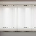 White Vertical Blinds In Modern Indoor Setting With Wooden Wall And Ceiling Lights