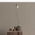 White Flower In Ceramic Vase With Pinecones On Tabletop Against Gray Wall 3d model