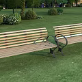 Public Benches With Wooden Slats And Metal Frames On Green Lawn With Trees And Bushes