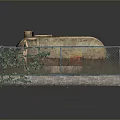 Old Oil Tank Enclosed In Fenced Area With Green Plants And Concrete Base