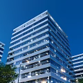 Modern High Rise Residential Building With Glass Curtain Walls And Exterior Night Lighting
