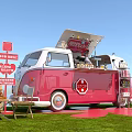 Vibrant Event Entrance Featuring Red And White Checkered Tents On Grass With Pink Flower Decorations