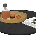 Whiskey Bottle and Glasses on Gold Round Tray with Open Magazine on Black Table