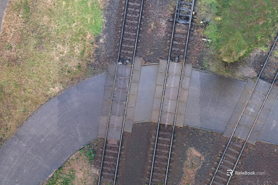 Railroad Crossing With Intersecting Train Tracks And Paved Surface Surrounded By Grass 3d model 