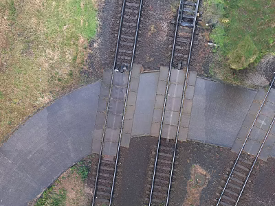 Railroad Crossing With Intersecting Train Tracks And Paved Surface Surrounded By Grass 3d model