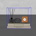 Stack of Detailed Interiors Books with Reed Diffuser Gray Sphere and Wooden Clock