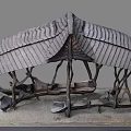 Natural Wooden Pavilion With Curved Tree like Pillars And Stone Bench Seats On Gravel Ground