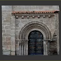 Stone Arched Entrance Gate With Black Door And Colorful Decorated Walls Red Tile Roof