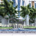 Modern Hotel Building with Palm Trees Water Fountain Glass Facade and White Pergola Landscaping