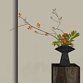 Black Vase with Orange Blooms Green Leaves and Branches on Wooden Pedestal with Sunlight Shadows