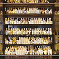 Liquor Cabinet With Multiple Shelves Filled With Various Wine And Whiskey Bottles