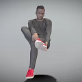 Man wearing gray long sleeve and gray pants lifting one leg to adjust red sneakers