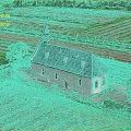Aerial View Of Green Countryside Farmland With Historic Church And Lush Trees