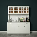 White Decorative Cabinet With Glass Doors Drawers And Vase Wine Bottles On Dark Green Wall