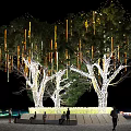 Illuminated Trees with Hanging Light Decorations at Nighttime People Gathered Underneath and Bright Trunks