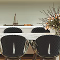 Modern Restaurant Dining Area With White Table Black Chairs Flower Arrangement And Wall Art
