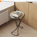 Round Side Table with Glass Top Metal Frame and Stack of Books Near Window