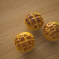 Three Fresh Golden Round Lattice Patterned Pastries on Wooden Tabletop