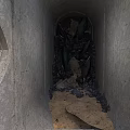 Concrete Tunnel Interior With Black Pipes Gravel And Sand Floor