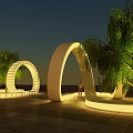 Illuminated Outdoor Chair In Park With Circular Light Structures And Trees At Night