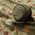 Fabric With Floral Patterns And A Round Container Placed On It 3d model