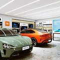 Xiaomi Auto Car Showroom Featuring Green And Orange Electric Vehicles With Display Screens And Cabinets