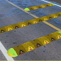 Road Infrastructure Featuring Yellow Black Speed Bumps and Asphalt Traffic Lines