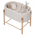 Light Colored Padded Baby Crib With Wooden Frame And Plush Rabbit Toys