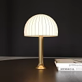 Dome Shaped Table Lamp With White Vertical Striped Lampshade And Golden Base On Desk