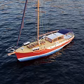 Red And Blue Sailboat Yacht With Tall Mast And Wooden Deck On Sea