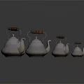 Set of Silver Teapots with Wooden Handles in Various Sizes Arranged Neatly