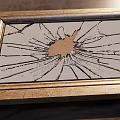 Broken Mirror with Golden Frame and Cracked Glass on Wooden Floor