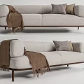Light Colored Two Seater Sofa With Checkered Pillows Brown Blanket And Dark Legs