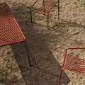 Outdoor Red Woven Table and Chair Set on Sandy Ground with Grass and Sunlight Shadows