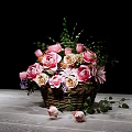 Pink and Beige Flower Arrangement in Wicker Basket with Green Leaves on Wooden Table
