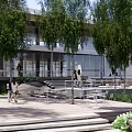 Modern Urban Plaza Landscape With Lush Trees Wooden Steps And Contemporary Buildings